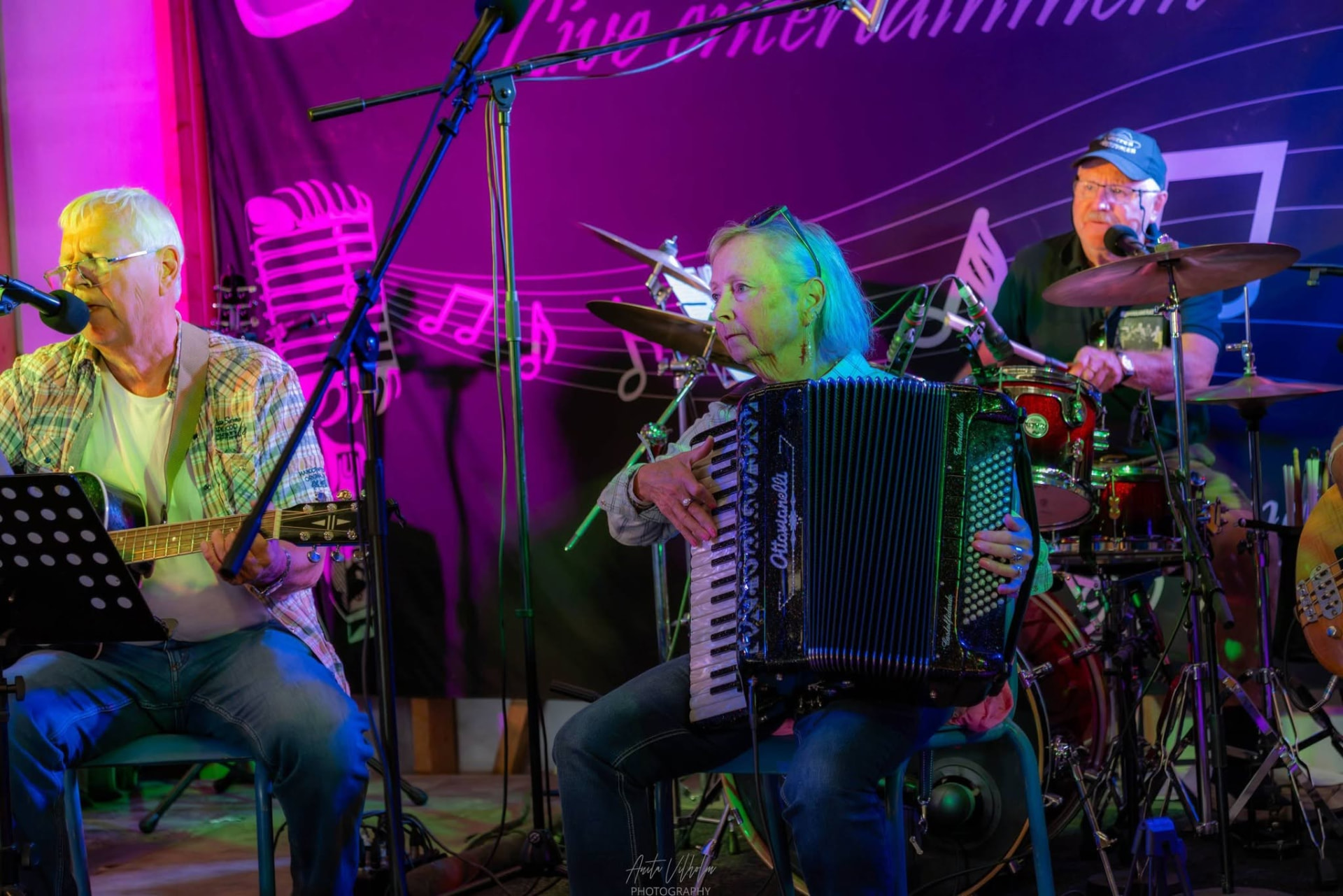 Trio med gitar, trekkspill og trommer på scenen